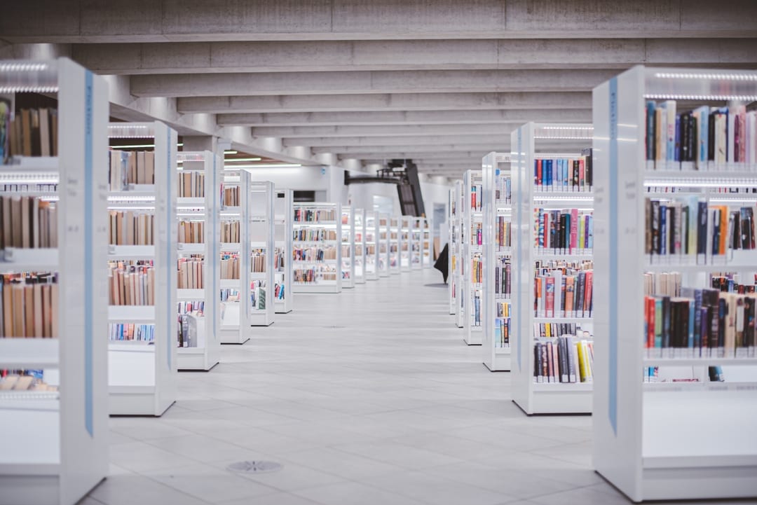 Rows of white bookshelves in a modern library