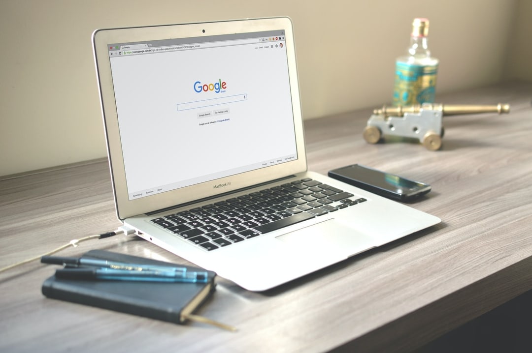 Laptop open to a search page on a wooden desk