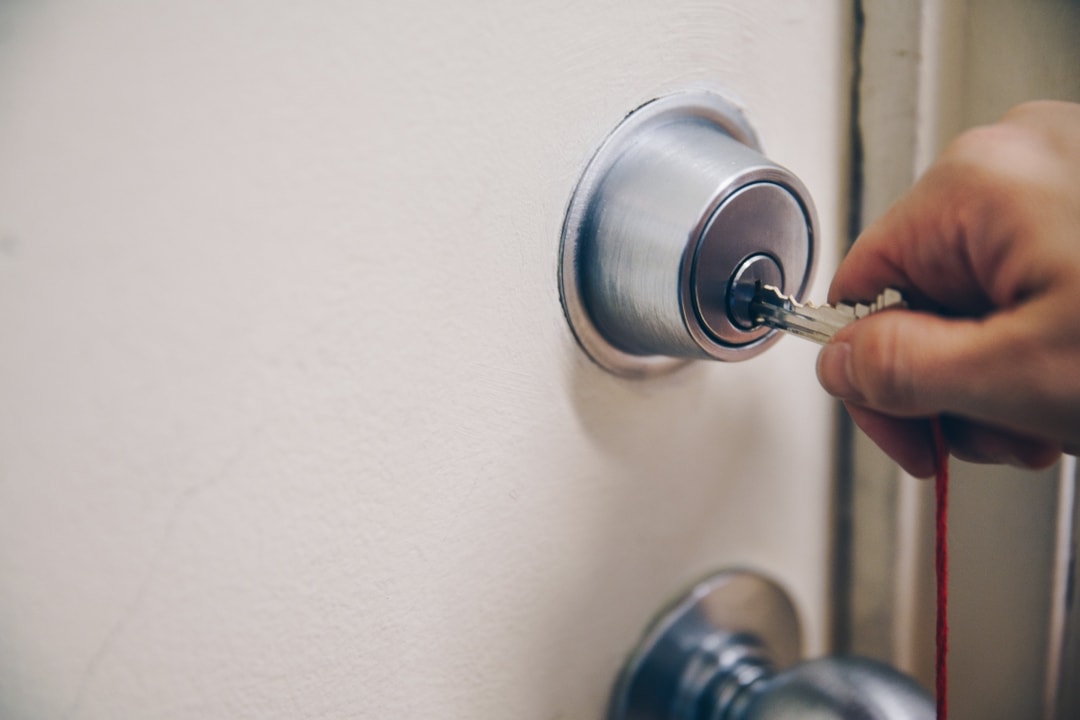 A hand inserting a key into a door lock