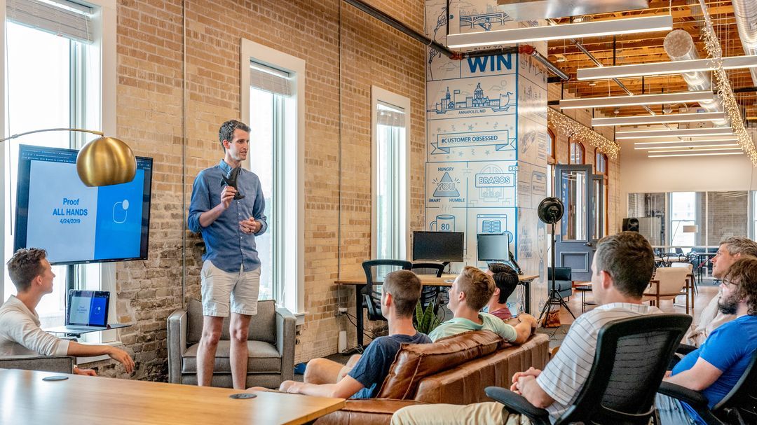 A team lead presenting to engaged colleagues in a modern office