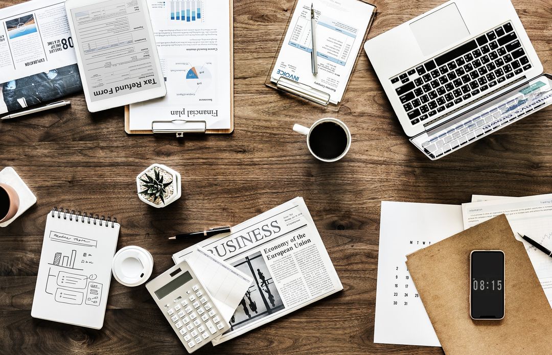 A flat lay of business, tax, and financial planning documents on a desk
